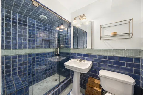 a bathroom with a sink mirror and toilet