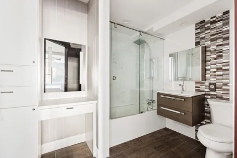 a bathroom with a sink a toilet and shower