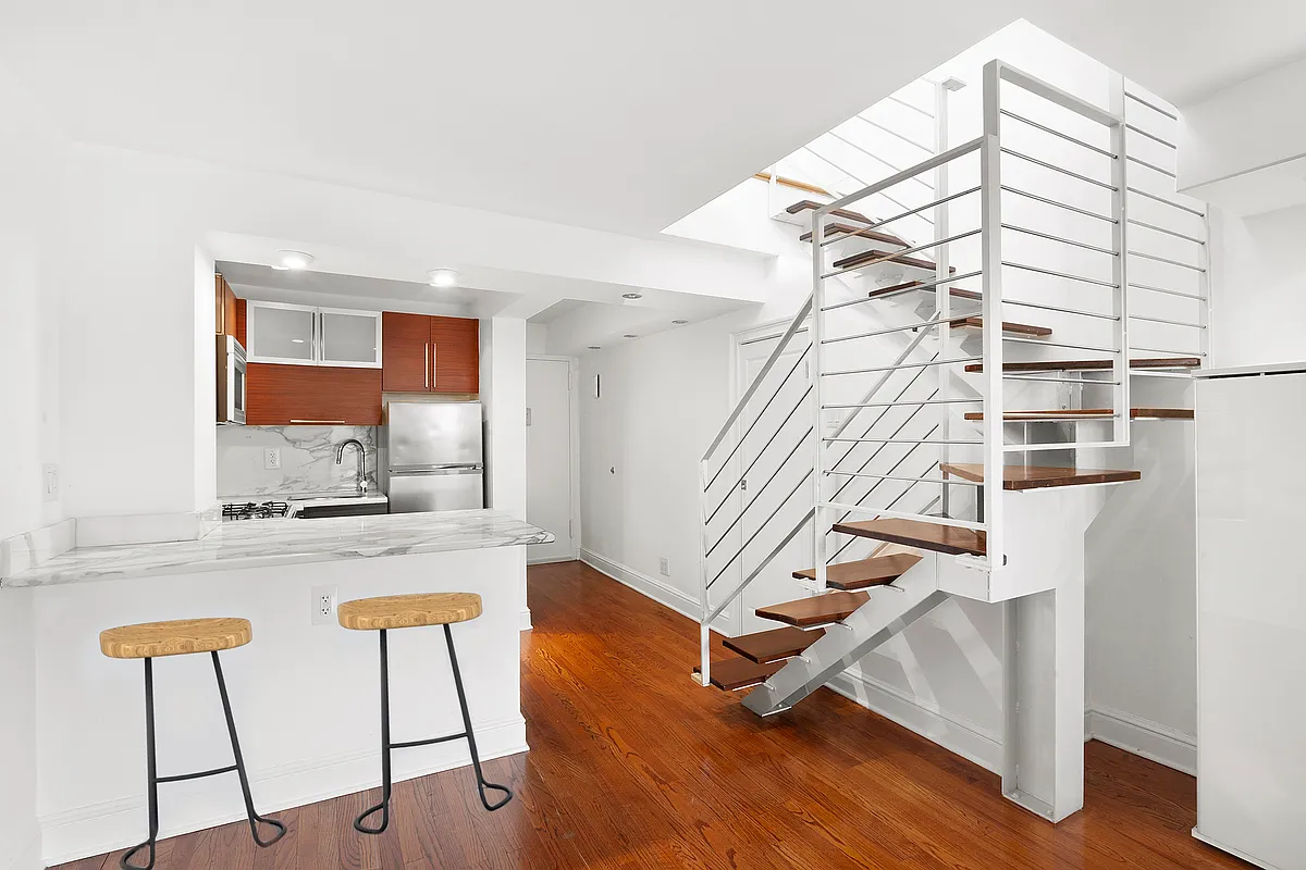 184 Thompson Street, Unit 6D Manhattan, NY 10012 - Photo 2 of 7 a view of entryway and kitchen with wooden floor