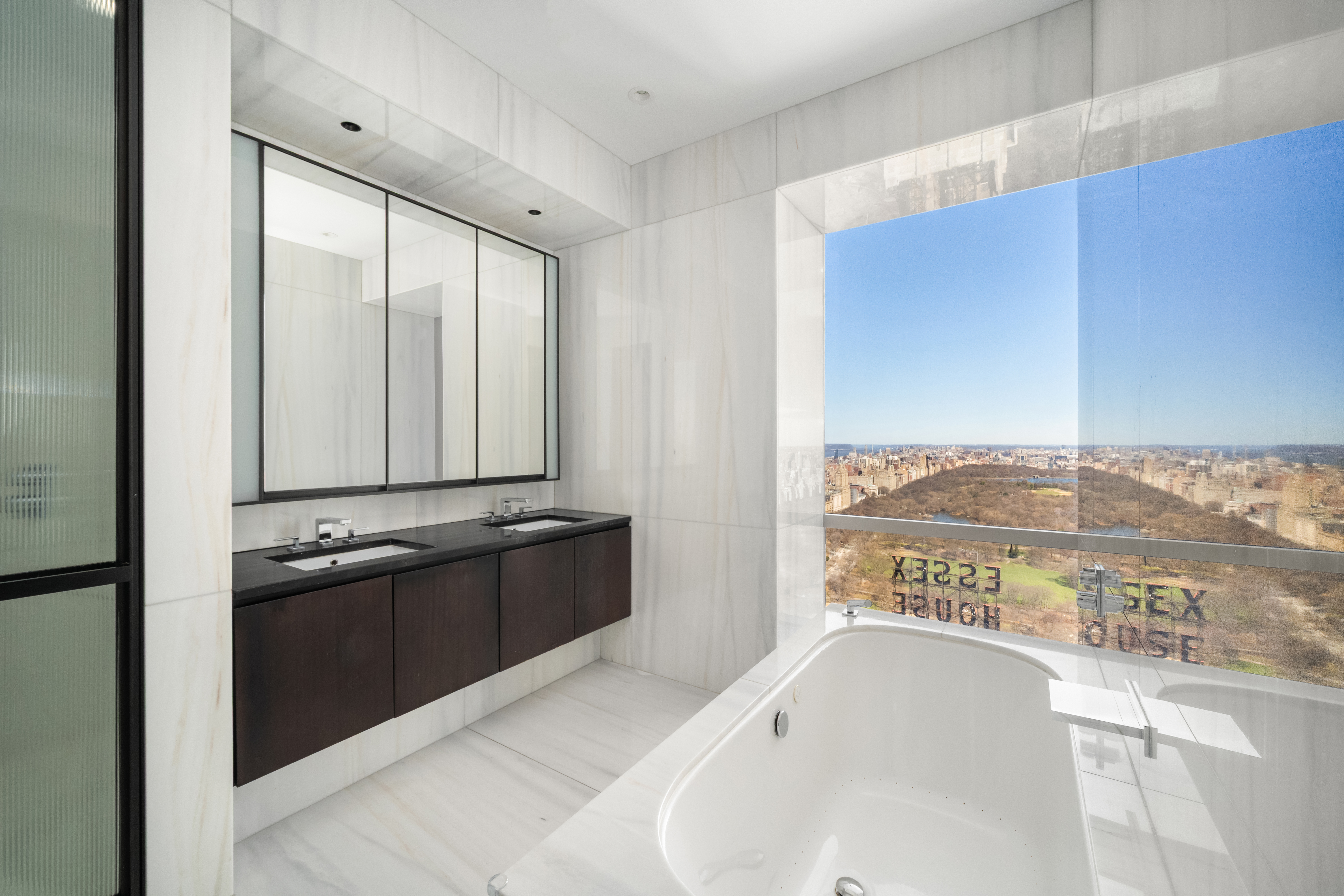 157 West 57th Street, Unit 56C Manhattan, NY 10019 - Photo 6 of 10 a bathroom with a tub sink and mirror