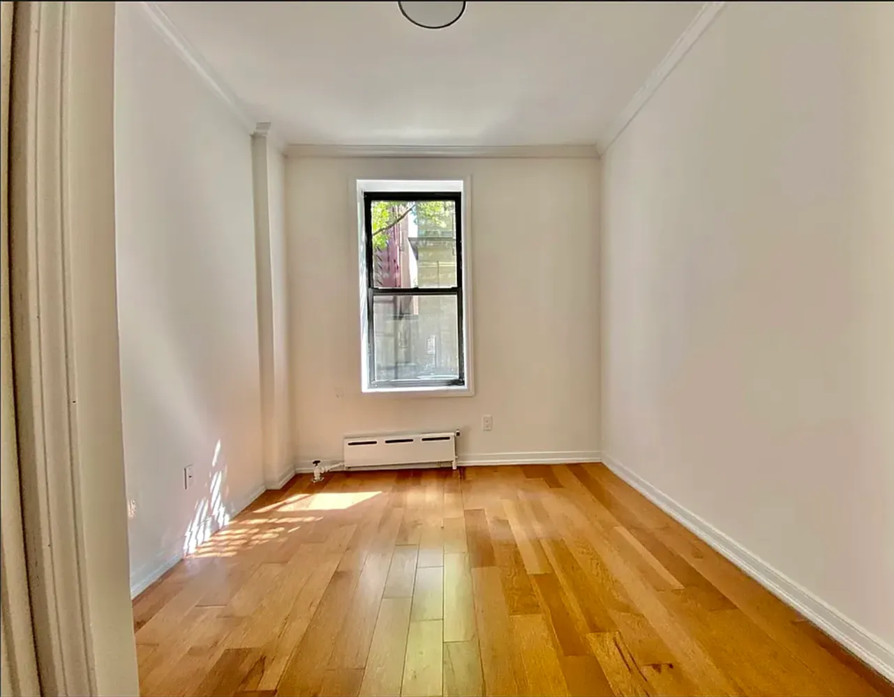a view of a room with wooden floor and fan