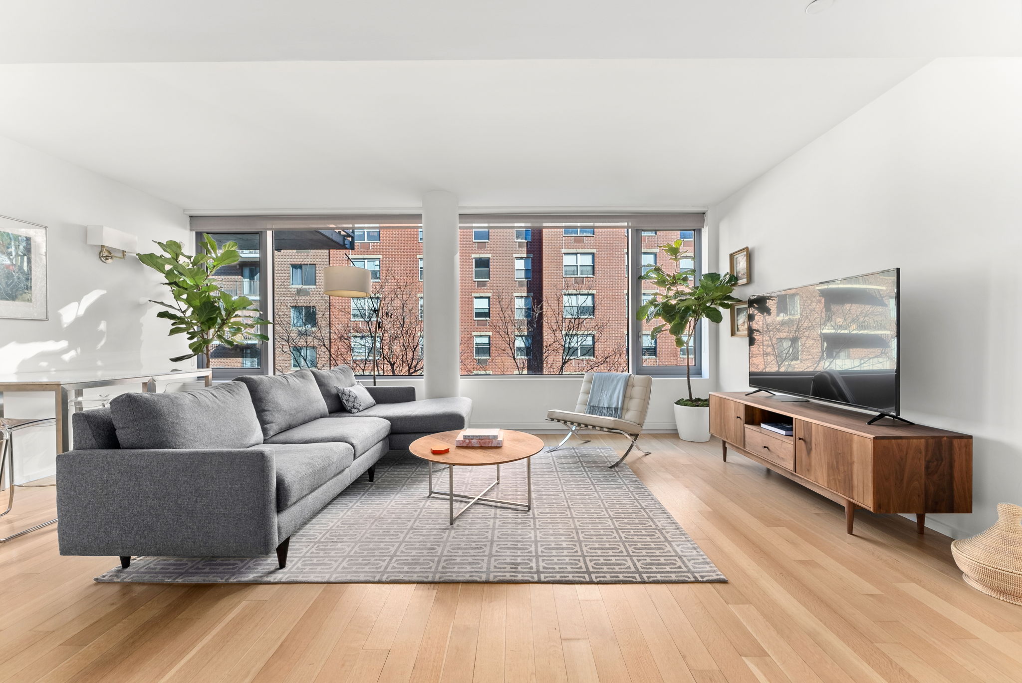 425 West 53rd Street, Unit 416 Manhattan, NY 10019 - Photo 1 of 19 a living room with furniture and a flat screen tv