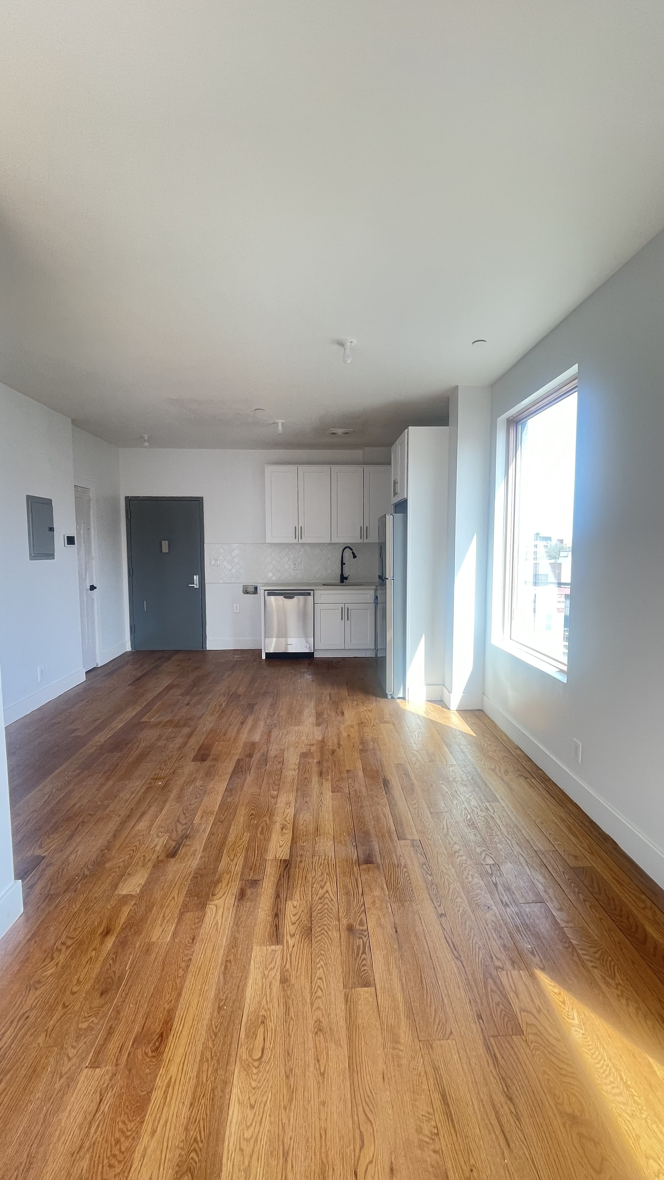 1010 Gates Avenue, Unit 6C Brooklyn, NY 11221 - Photo 4 of 9 a view of empty room with wooden floor and windows