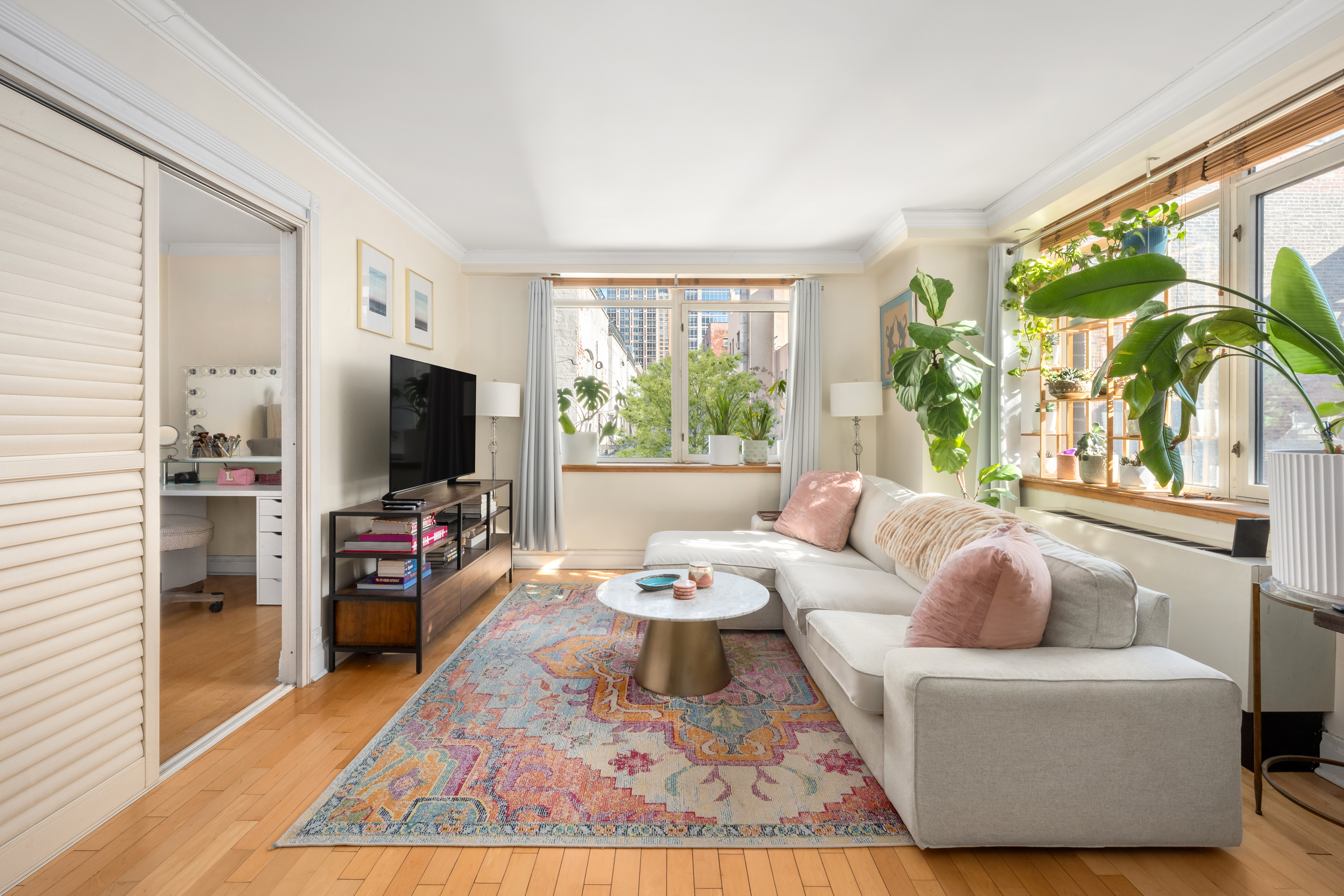 a living room with furniture a flat screen tv and a large window
