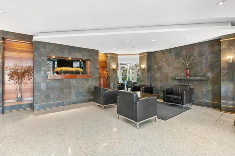 a living room with furniture a flat screen tv and a floor to ceiling window