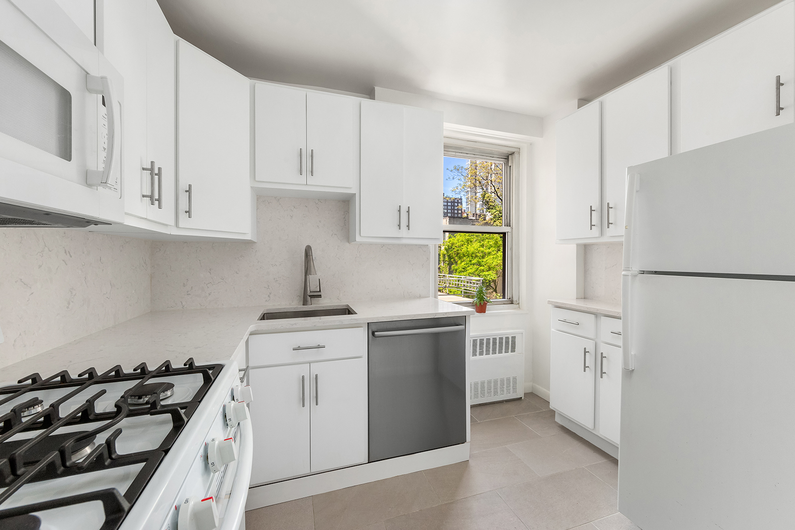 251 East 32nd Street, Unit 5J Manhattan, NY 10016 - Photo 6 of 15 a kitchen with white cabinets and white appliances