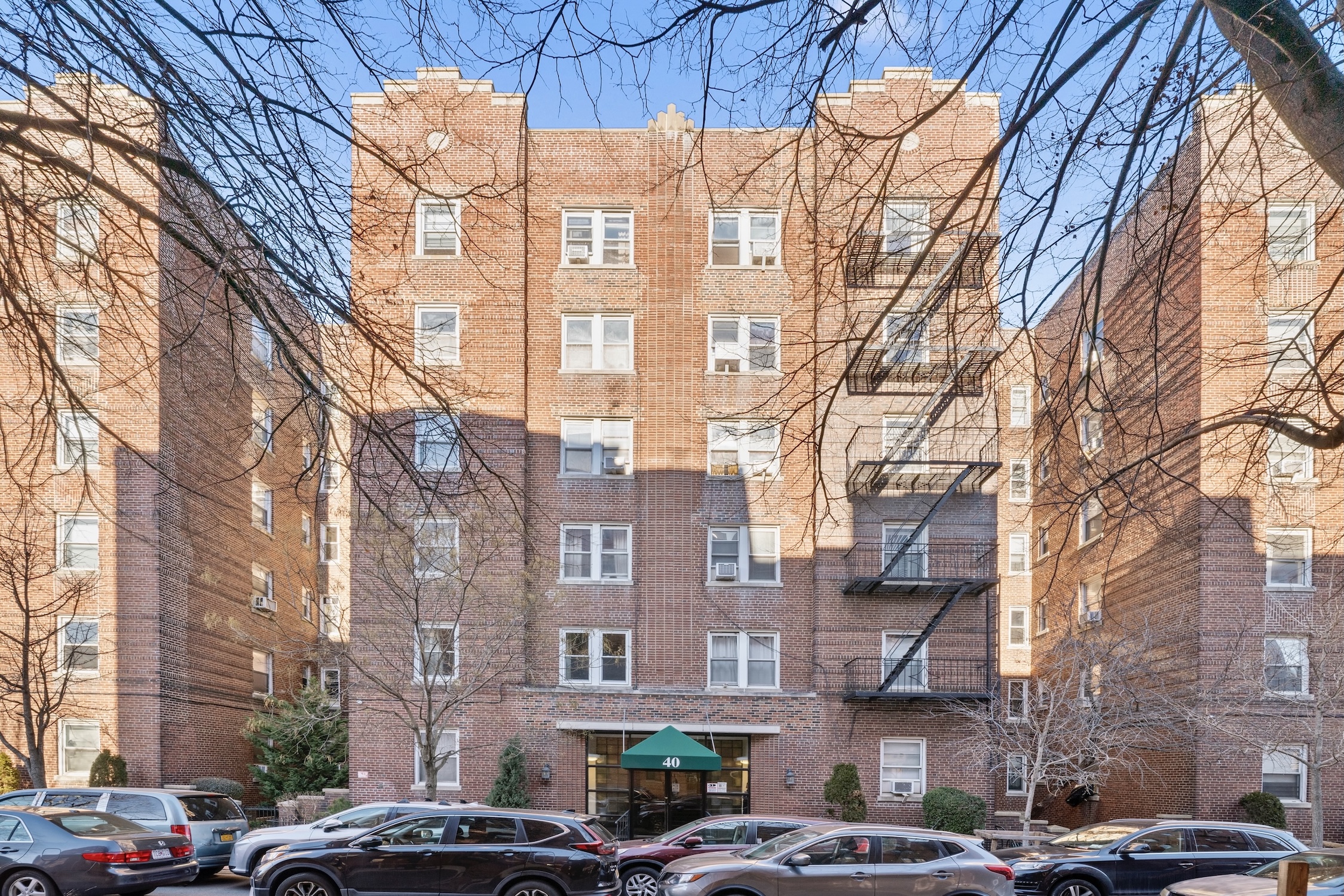 40 Tehama Street, Unit 6E Brooklyn, NY 11218 - Photo 13 of 16 a front view of a building with lot of cars and trees