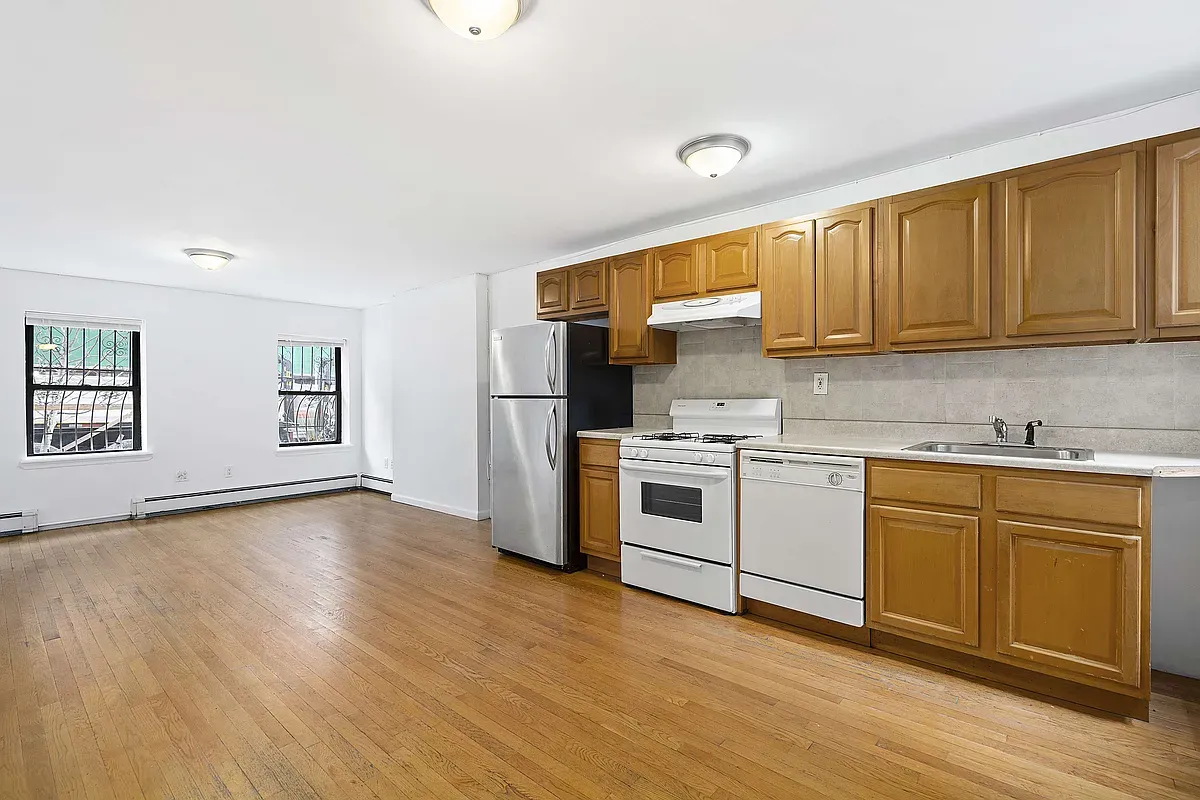 a kitchen with a sink cabinets stainless steel appliances and wooden floor