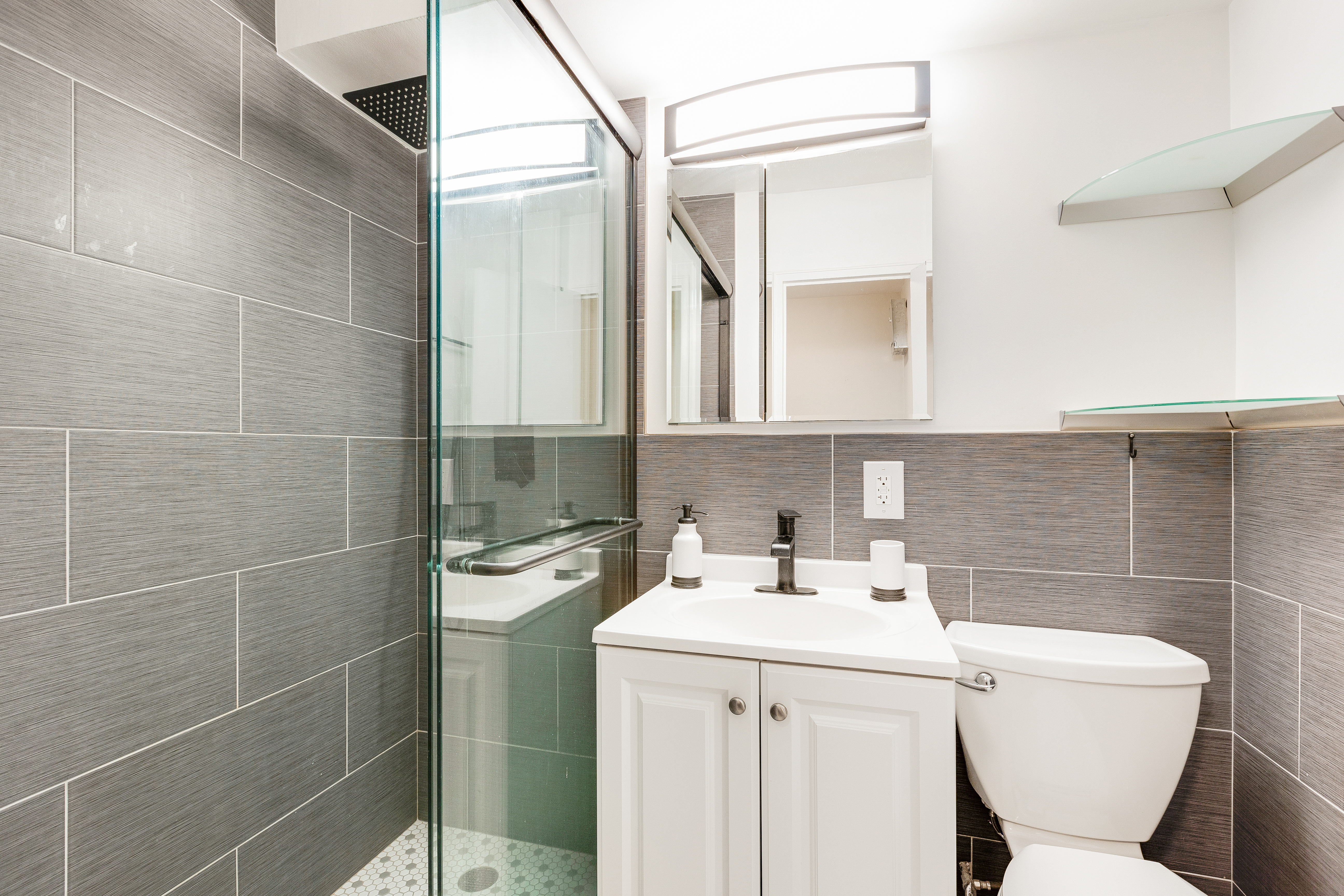 240 East 76th Street, Unit 9A Manhattan, NY 10021 - Photo 7 of 9 a bathroom with a toilet sink and mirror