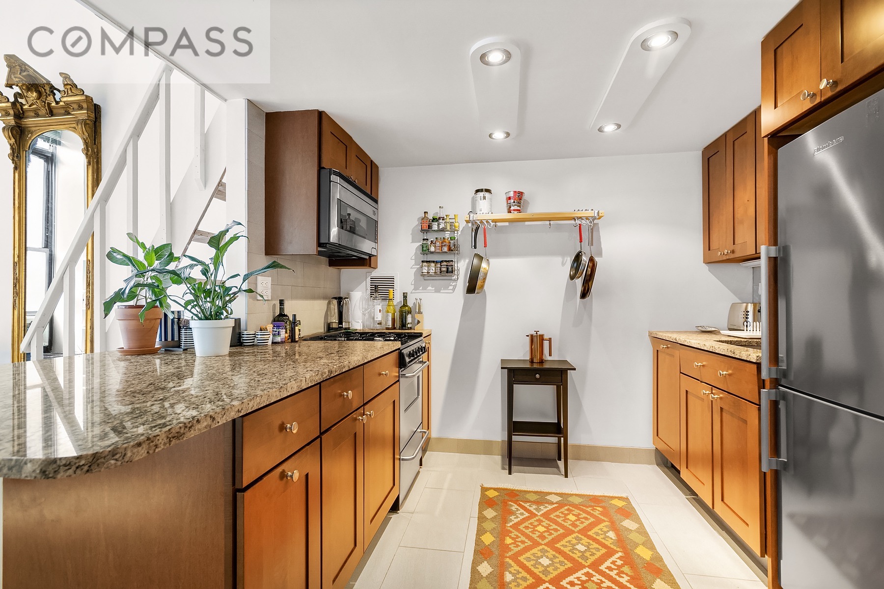 250 Mercer Street, Unit C309 Manhattan, NY 10012 - Photo 5 of 8 a kitchen with stainless steel appliances kitchen island granite countertop a refrigerator and a sink