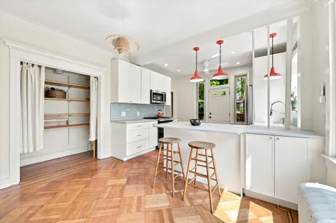 a kitchen with white cabinets and stainless steel appliances