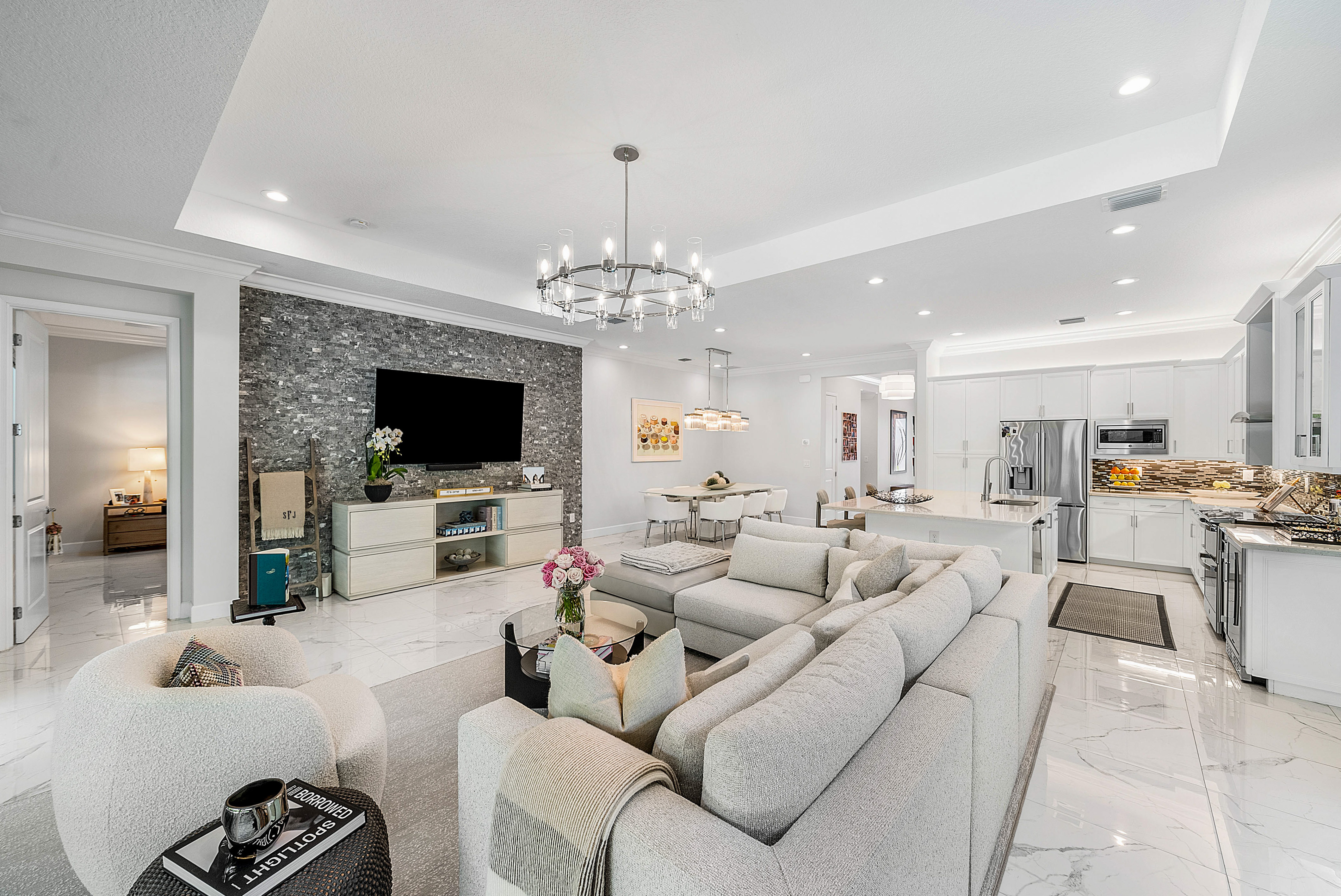 13172 Whistler Mountain Road Delray Beach, FL 33446 - Photo 10 of 38 a living room with furniture a flat screen tv and a chandelier