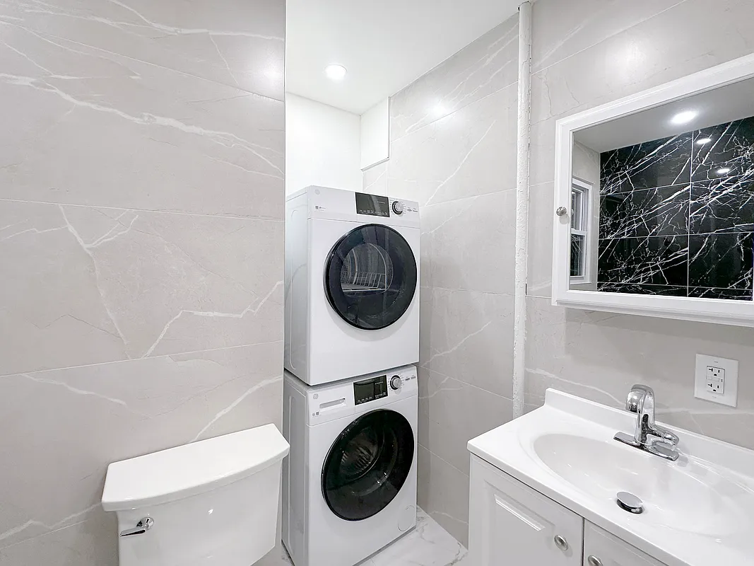 55 Spring Street, Unit 7 Manhattan, NY 10012 - Photo 9 of 12 a bathroom with a sink a toilet and a mirror