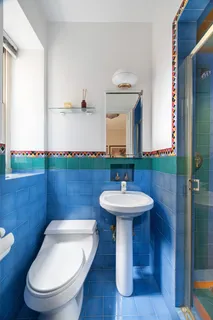 a bathroom with a toilet a sink and mirror