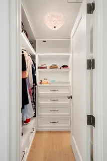a view of walk in closet with clothes and shoes
