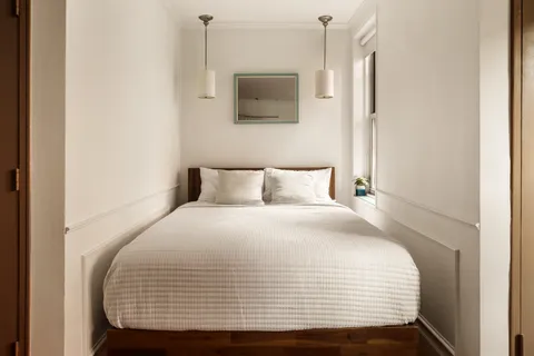 a bedroom with a bed and a wall painting