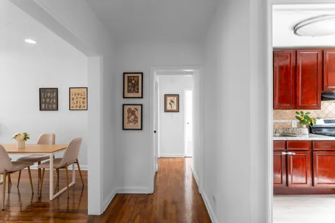 a view of a hallway with furniture and wooden floor