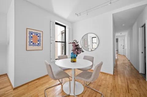 a view of a dining room with furniture a chandelier and wooden floor