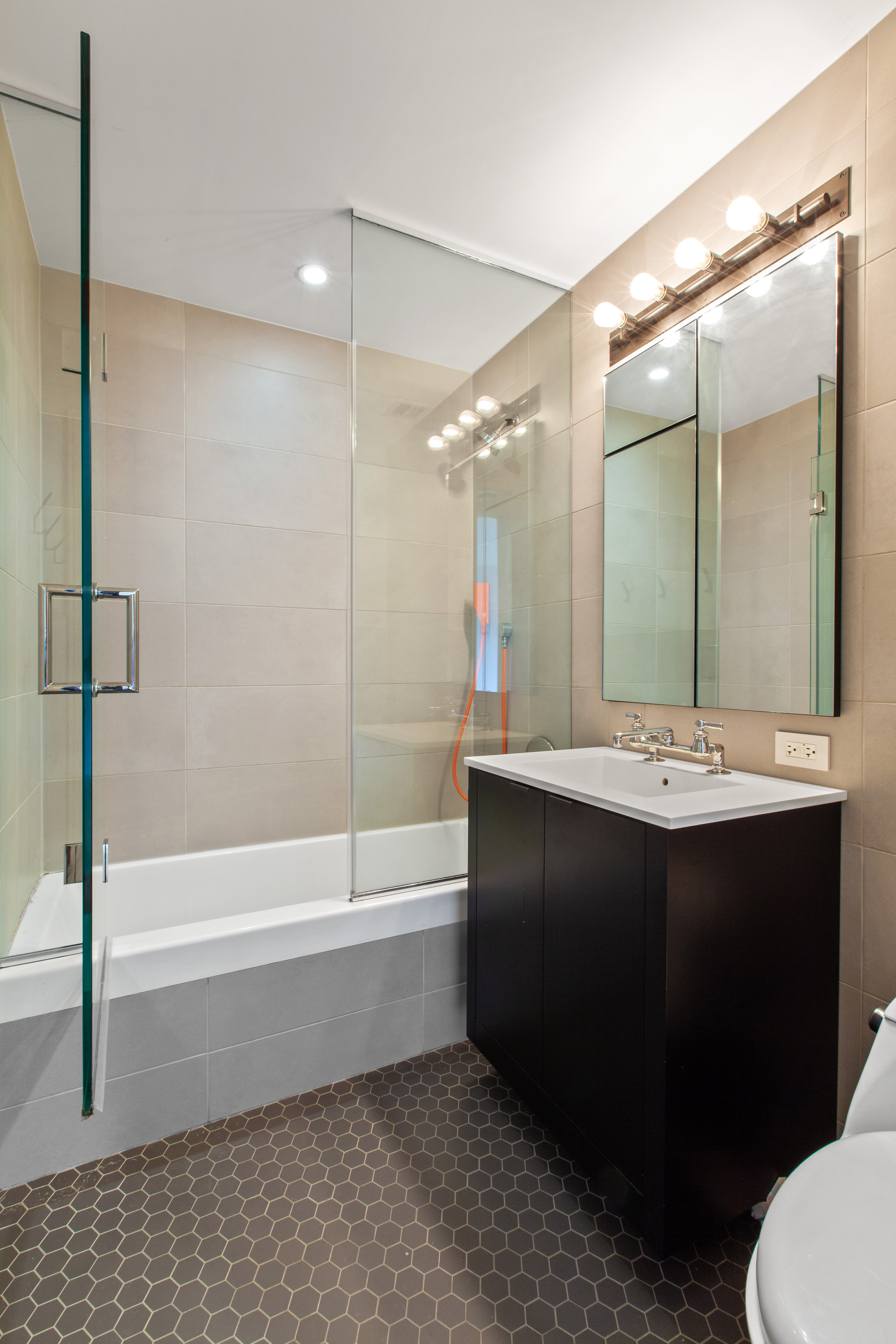 540 West 28th Street, Unit 4F Manhattan, NY 10001 - Photo 8 of 16 a bathroom with a bathtub a sink and a mirror