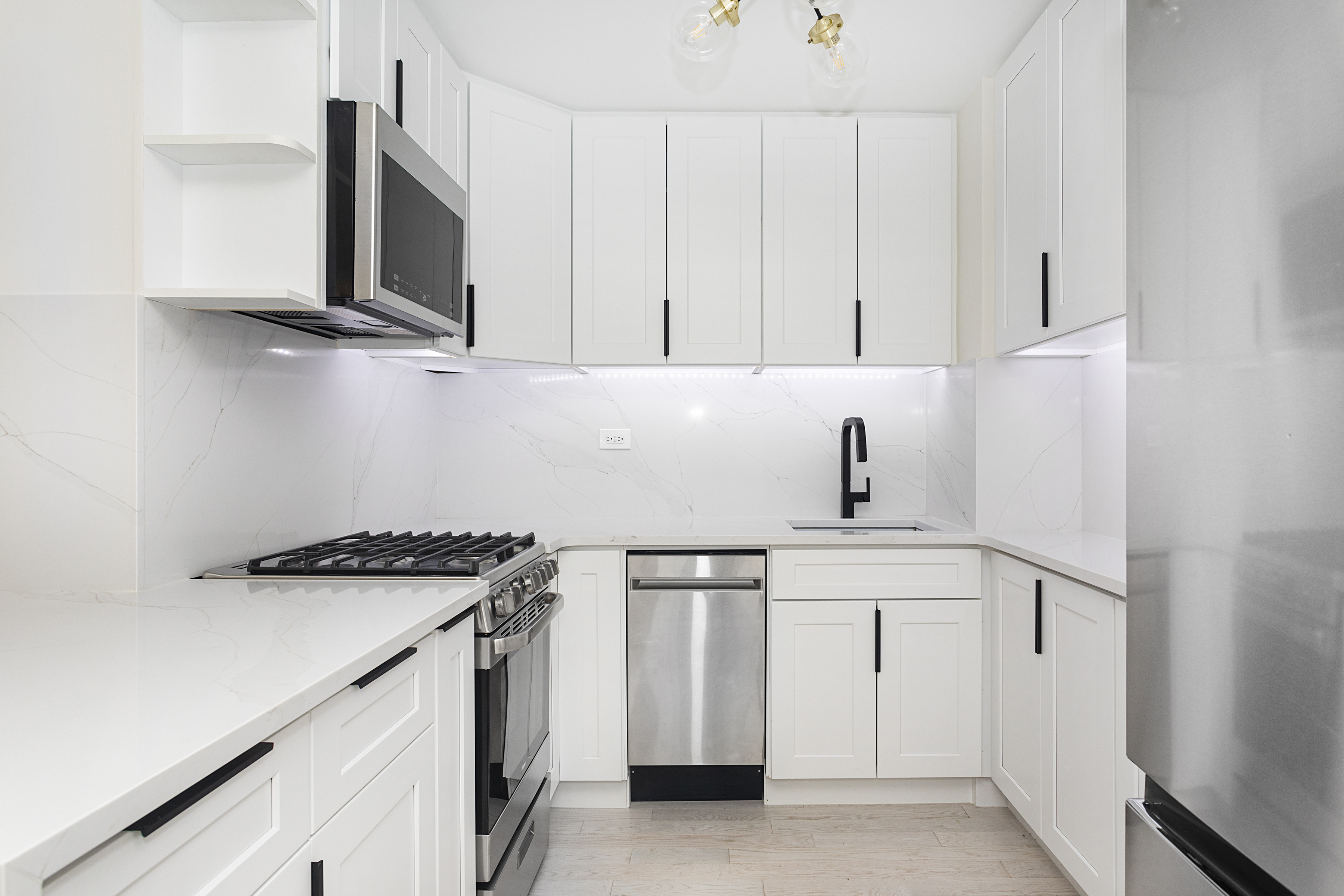 165 Christopher Street, Unit 1C Manhattan, NY 10014 - Photo 2 of 10 a kitchen with stainless steel appliances a sink a stove and microwave