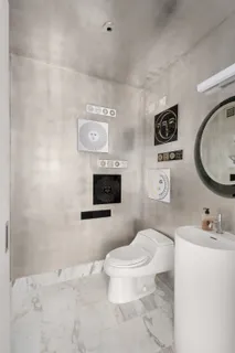 a bathroom with a toilet sink a mirror and vanity