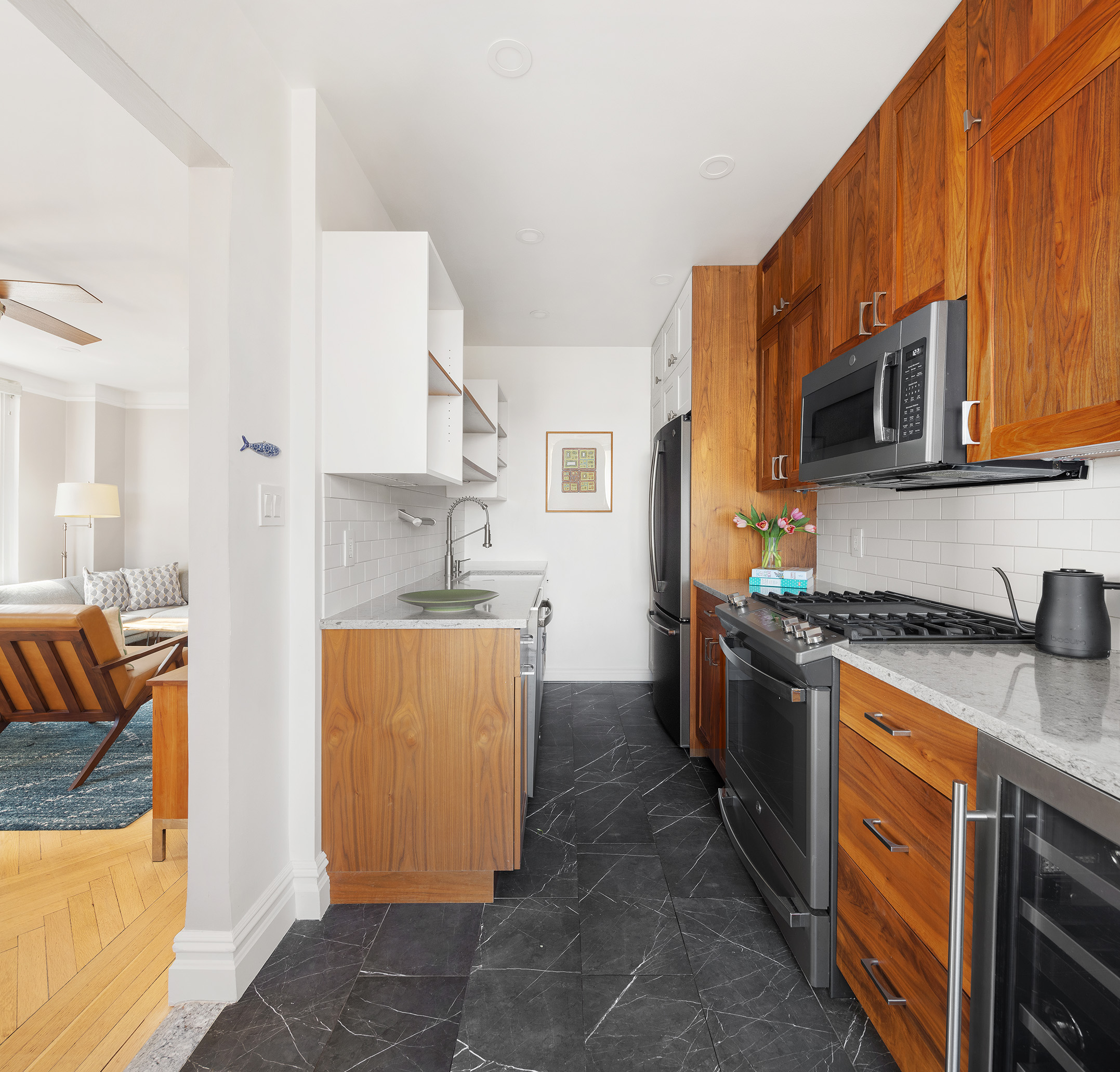 39 Plaza Street West, Unit 7C Brooklyn, NY 11217 - Photo 5 of 12 a kitchen with stainless steel appliances granite countertop a stove top oven a sink a refrigerator and white cabinets with wooden floor