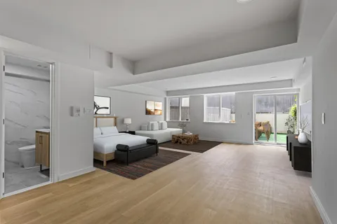 a large bedroom with a bed and wooden floor