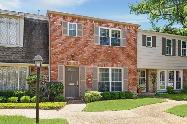 a front view of a house with a garden and plants