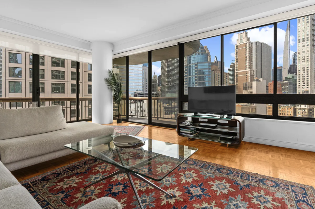 a living room with furniture and floor to ceiling windows