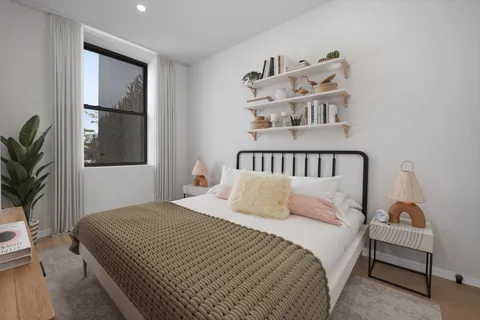 a bedroom with a bed and wooden floor