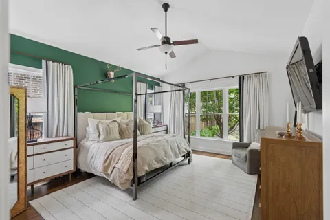 a bedroom with a bed window and a flat screen tv