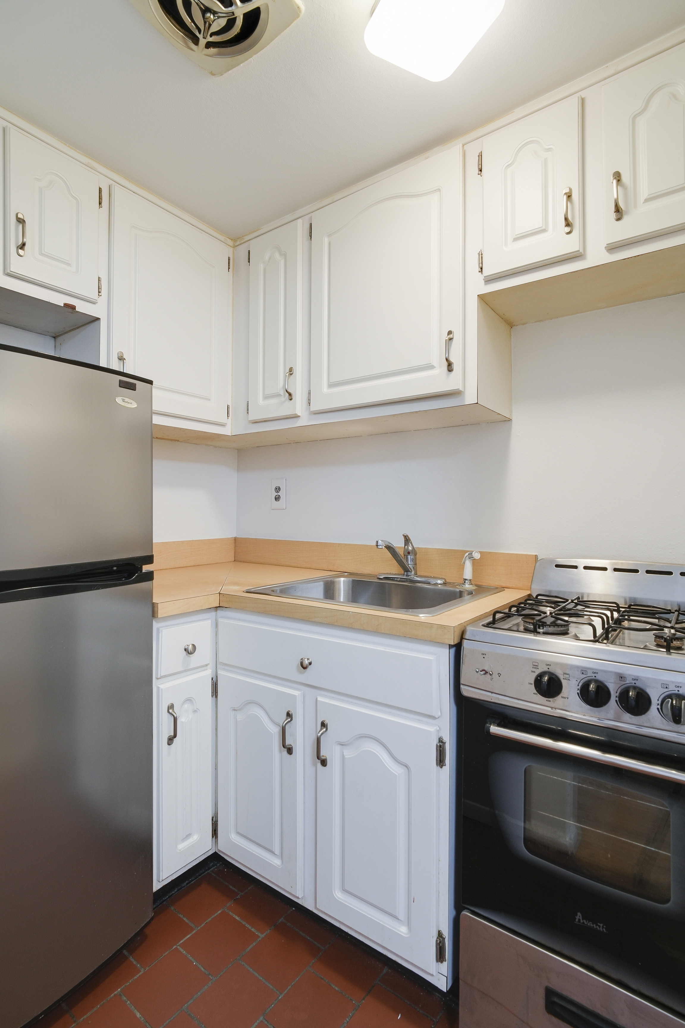 160 East 26th Street, Unit 5F Manhattan, NY 10010 - Photo 6 of 10 a kitchen with granite countertop white cabinets and white appliances