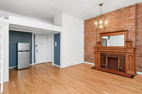 a view of empty room with wooden floor and fireplace