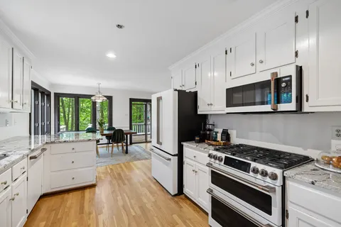a kitchen with granite countertop white cabinets and a window