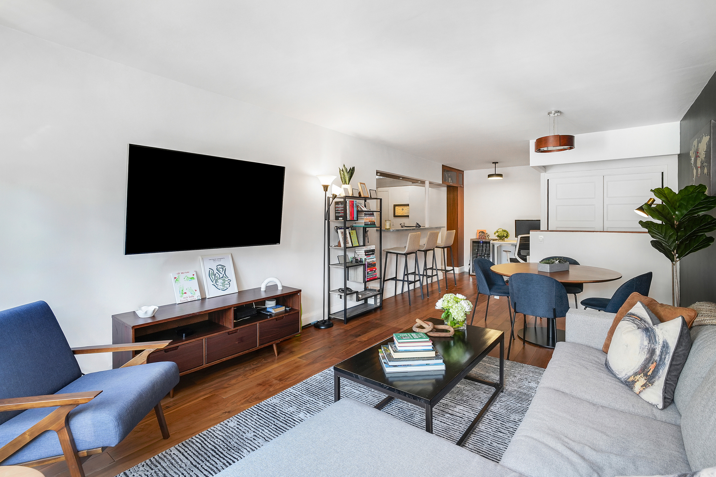 220 East 54th Street, Unit 11H Manhattan, NY 10022 - Photo 2 of 13 a living room with furniture and a flat screen tv