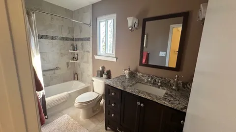 a bathroom with a granite countertop sink toilet and shower