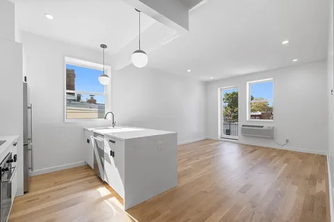 a kitchen with cabinets and wooden floor
