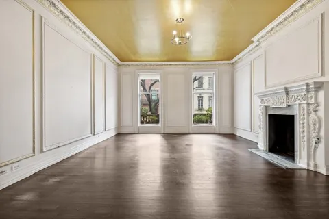 a view of an empty room with window and fireplace