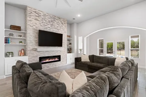 a kitchen with stainless steel appliances kitchen island granite countertop a refrigerator a stove a sink dishwasher and white cabinets with wooden floor