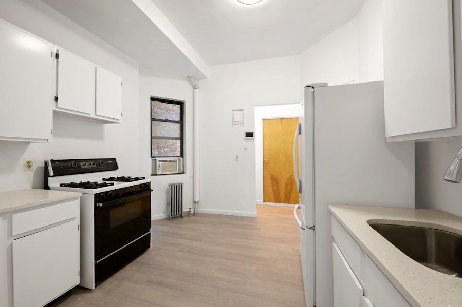 312 West 49th Street, Unit 1RW Manhattan, NY 10019 - Photo 10 of 12 a kitchen with a stove and a refrigerator