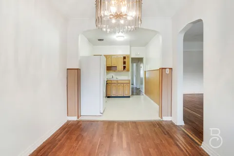 a view of a big room with wooden floor and chandelier