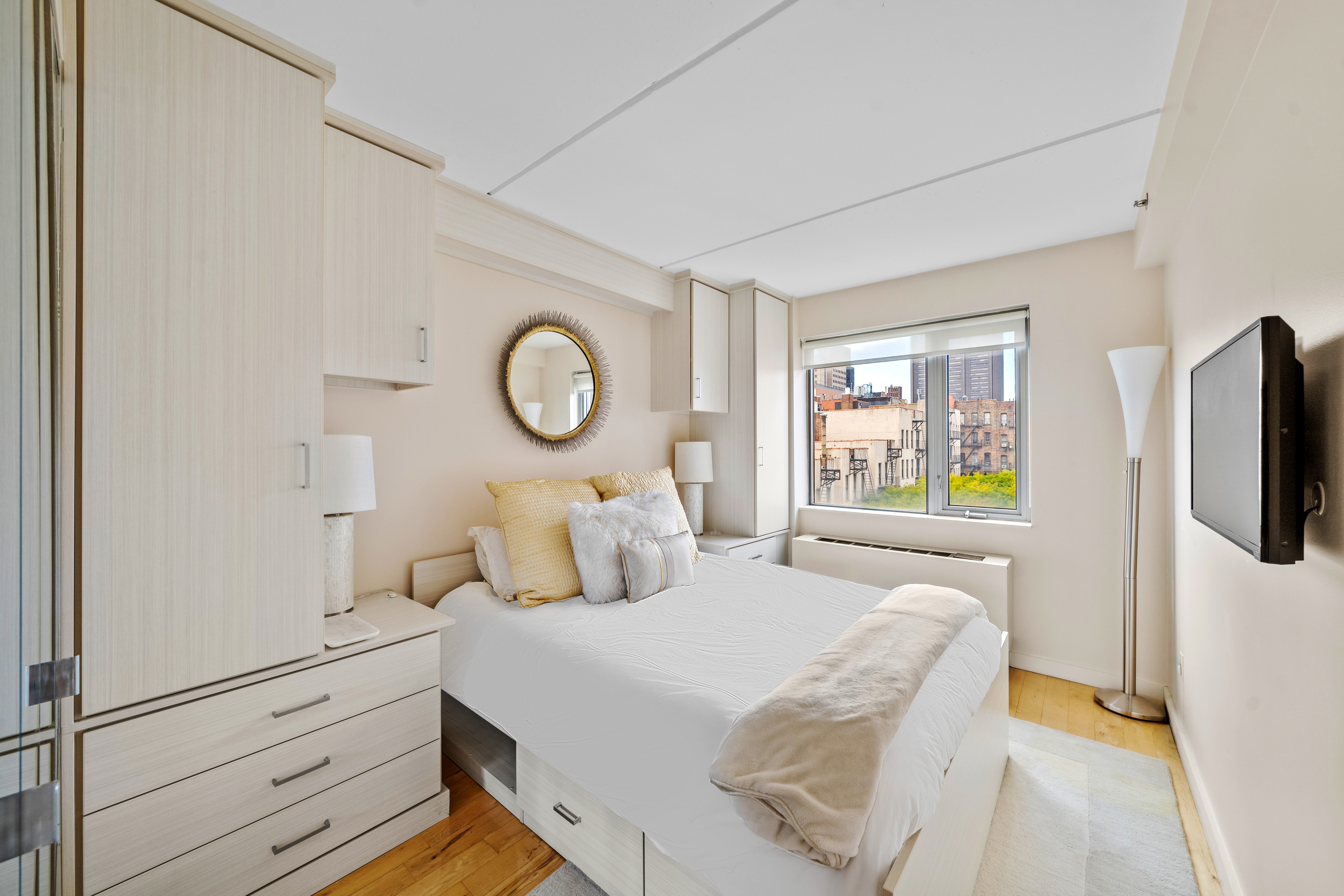 1810 3rd Avenue, Unit A9B Manhattan, NY 10029 - Photo 9 of 16 a bedroom with a bed and a flat tv screen on dresser