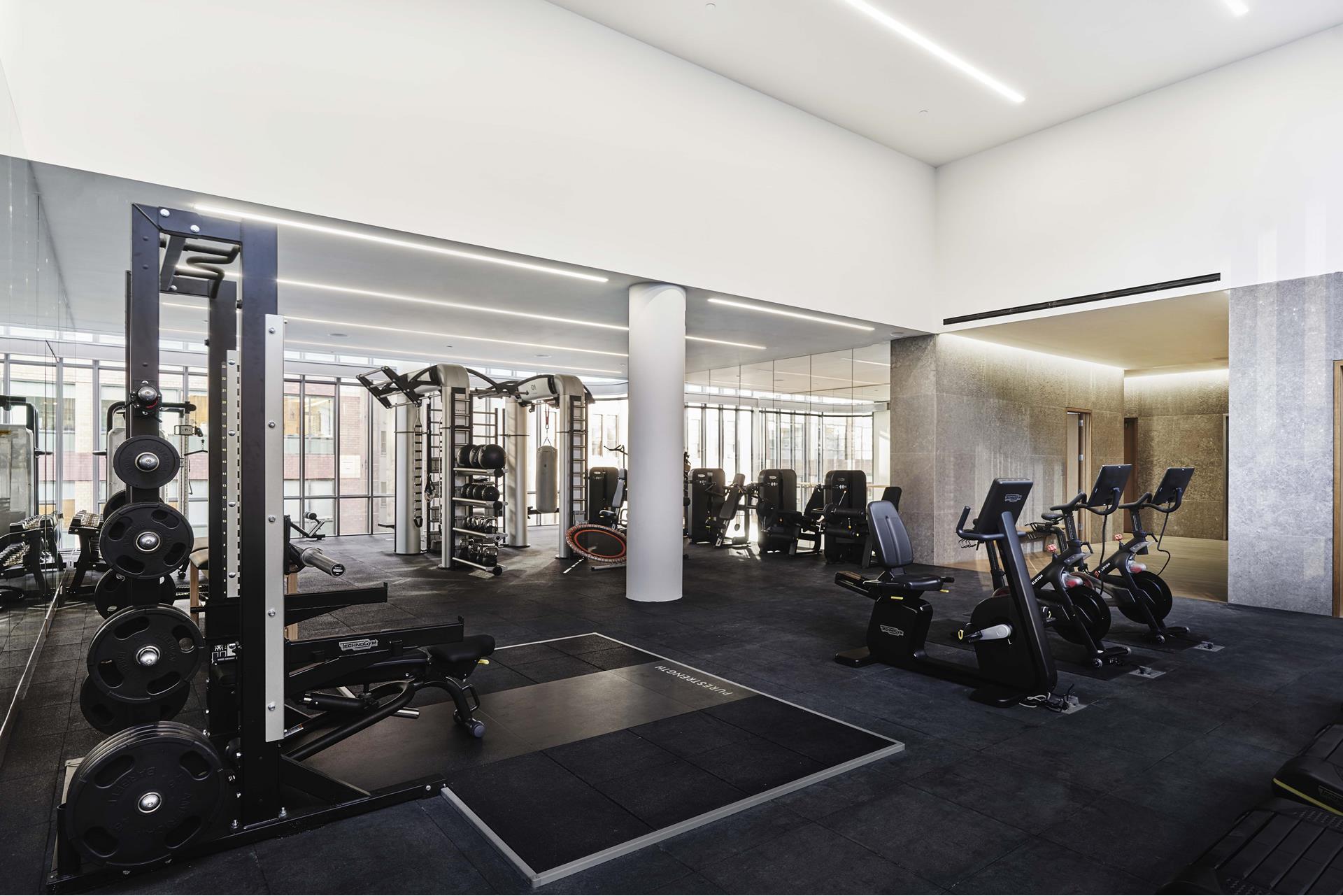 565 Broome Street, Unit N12E Manhattan, NY 10013 - Photo 16 of 19 a room with gym equipment and large mirror