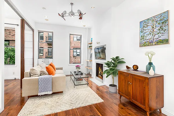 13 Downing Street, Unit 8 Manhattan, NY 10014 - Photo 1 of 10 a living room with furniture and wooden floor