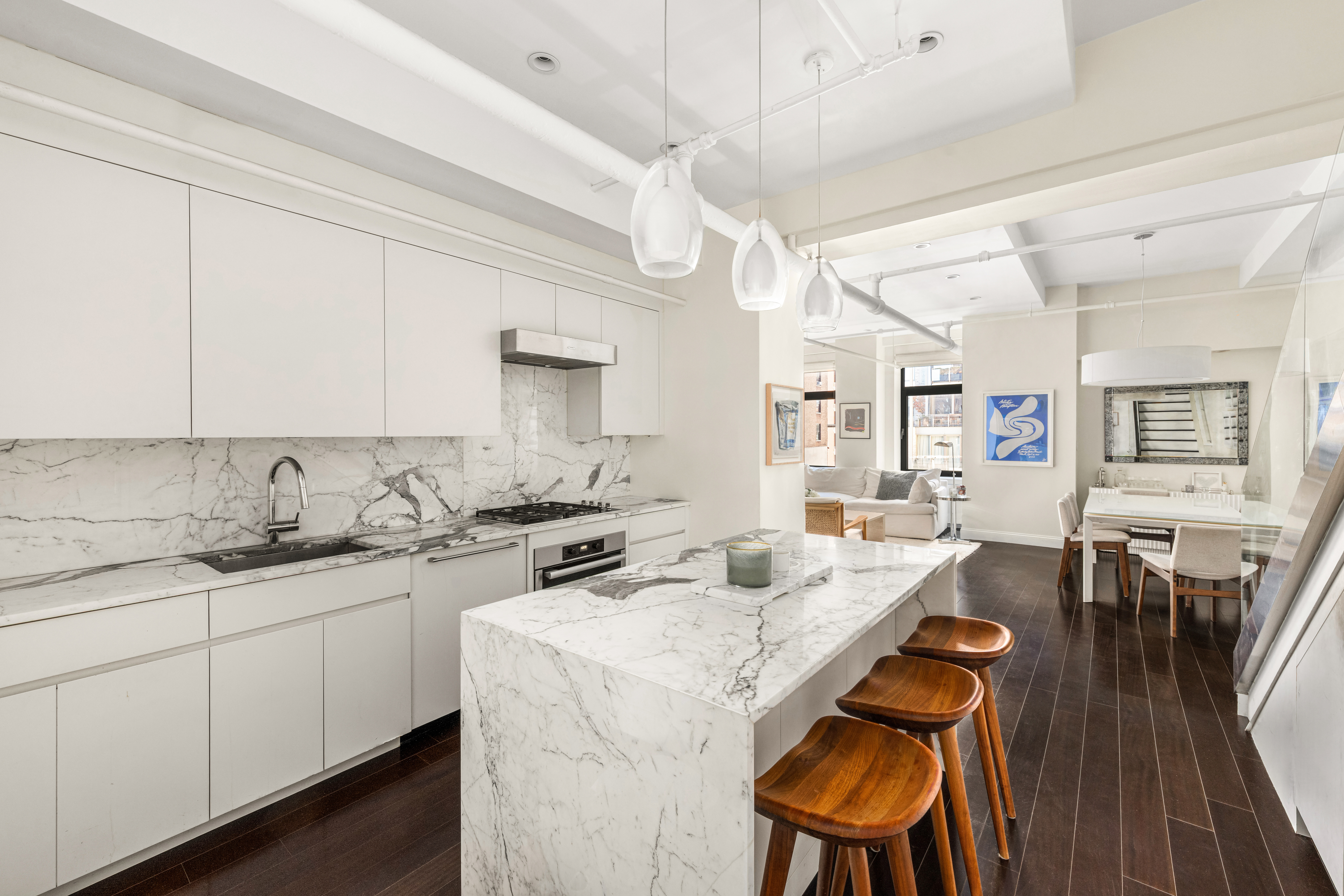 14 East 4th Street, Unit 803 Manhattan, NY 10012 - Photo 4 of 11 a kitchen with a sink a stove cabinets dining table and chairs