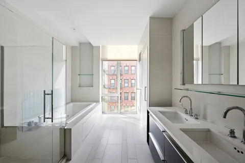 a bathroom with a tub sink and mirror