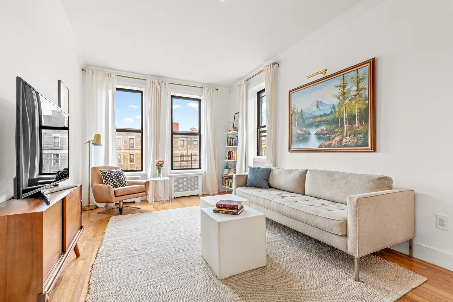 a living room with furniture wooden floor and a large window