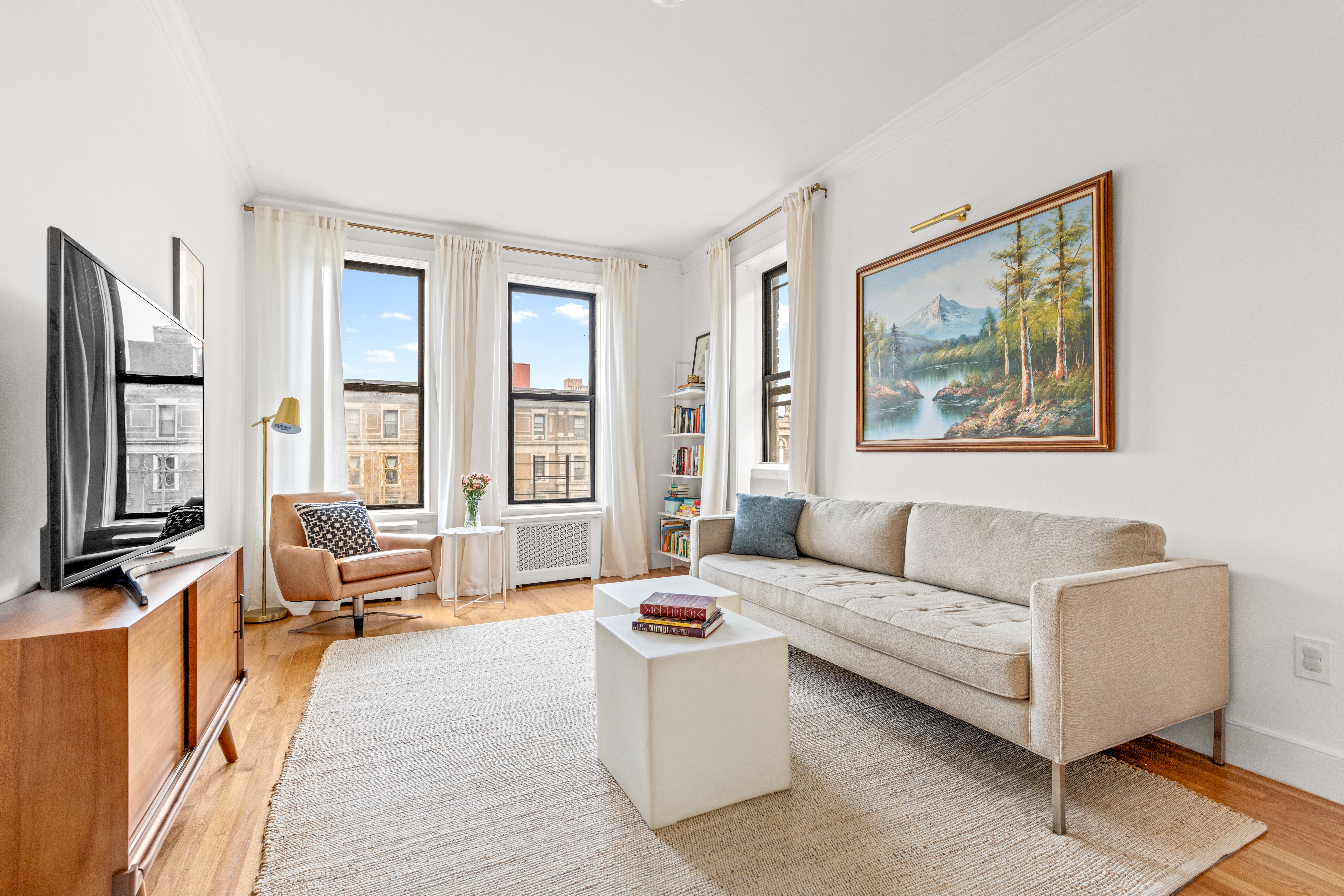 a living room with furniture wooden floor and a large window