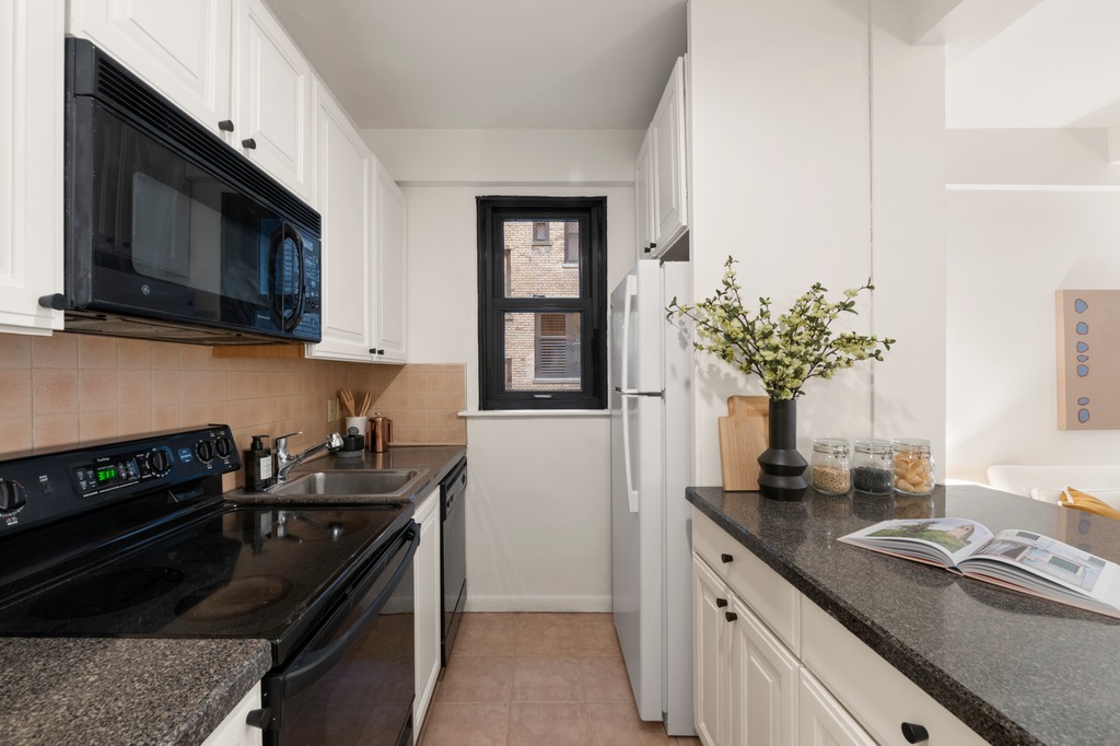 251 West 74th Street, Unit 3B Manhattan, NY 10023 - Photo 4 of 7 a kitchen with stainless steel appliances granite countertop a sink stove and microwave