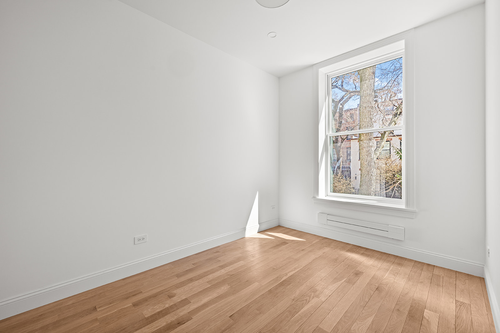 119 Henry Street, Unit 3 Brooklyn, NY 11201 - Photo 10 of 14 an empty room with wooden floor and windows
